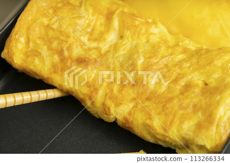 Tamagoyaki process: pouring in the eggs 113266334