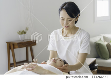 A middle-aged female esthetician performing a treatment A middle-aged female esthetician performing a treatment 113266352
