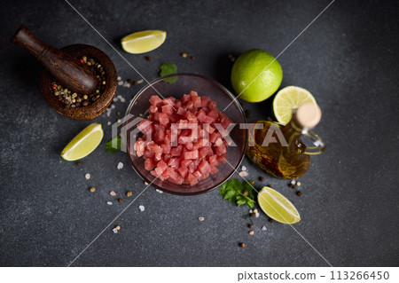 Sliced and chopped tuna fillet in glass bowl at domestic kitchen cooking traditional tartare 113266450