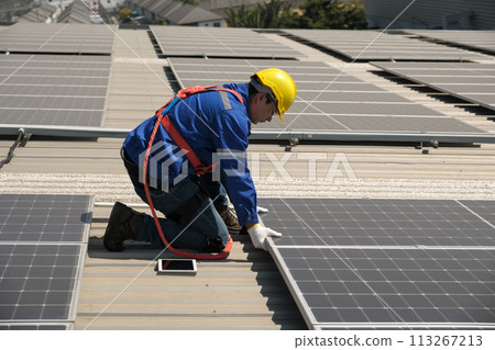 Engineers install solar cells on the roof of factory 113267213