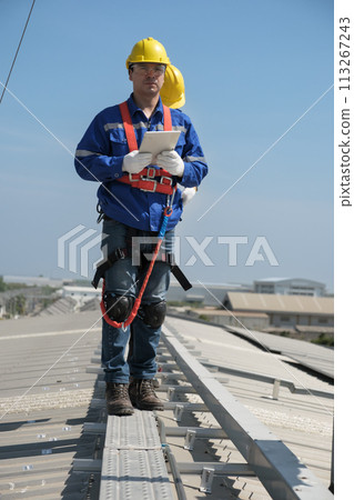 Engineers install solar cells on the roof of factory Engineers install solar cells on the roof of factory 113267243