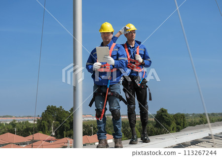Engineers install solar cells on the roof of factory 113267244