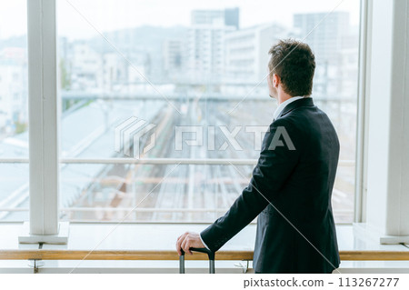 Foreign businessman looking at the tracks at a station or terminal (train, bullet train, station) Foreign businessman looking at the tracks at a station or terminal (train, bullet train, station) 113267277