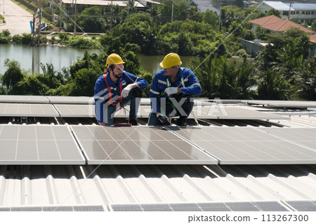 Engineers install solar cells on the roof of factory Engineers install solar cells on the roof of factory 113267300