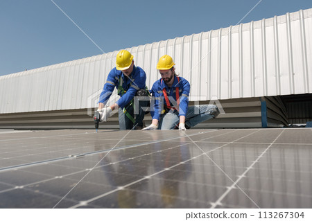 Engineers install solar cells on the roof of factory 113267304