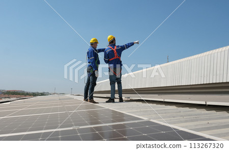 Engineers install solar cells on the roof of factory 113267320