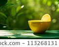 Sip of Sunshine: Fresh Orange Juice and Lemon Slice on Green Backdrop 113268131