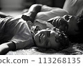 Dreamland Embrace: Side View Portrait of Young Father Falling Asleep with Adorable Little Child 113268135