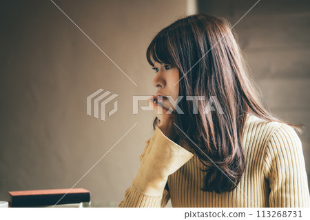A woman thinking with a troubled expression A woman thinking with a troubled expression 113268731