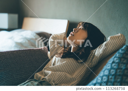 A woman leaning on a sofa and thinking A woman leaning on a sofa and thinking 113268738