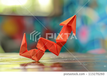 Red paper origami arrow symbolizes growth, rising trends, or success against a colorful, blurred backdrop Red paper origami arrow symbolizes growth, rising trends, or success against a colorful, blurred backdrop 113270260