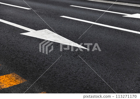 White arrows and lines, road marking on dark highway asphalt White arrows and lines, road marking on dark highway asphalt 113271170