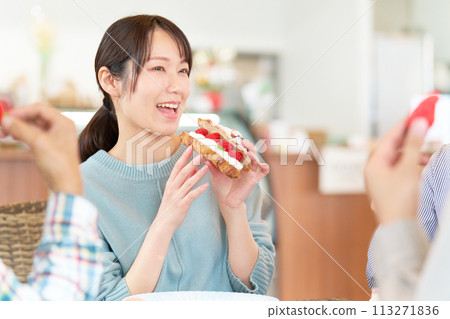 Young woman eating strawberry dessert at a cafe Young woman eating strawberry dessert at a cafe 113271836