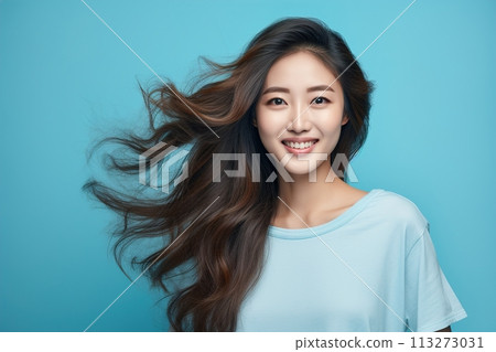 A woman with long brown hair is smiling and wearing a blue shirt 113273031
