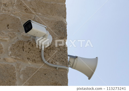 Surveillance Camera and Loudspeaker on Stone Wall 113273241