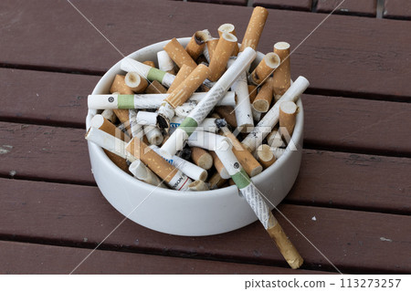 Overflowing Ashtray on Wooden Table Overflowing Ashtray on Wooden Table 113273257