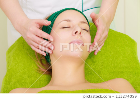 Woman getting traditional face massage in beautician Woman getting traditional face massage in beautician 113274059