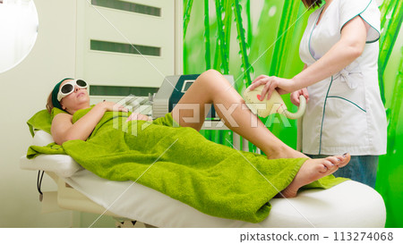 Woman getting laser treatment in beautician 113274068