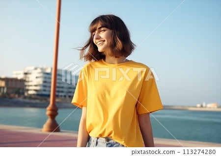A woman in red t-shirt and jeans smiles on beach 113274280