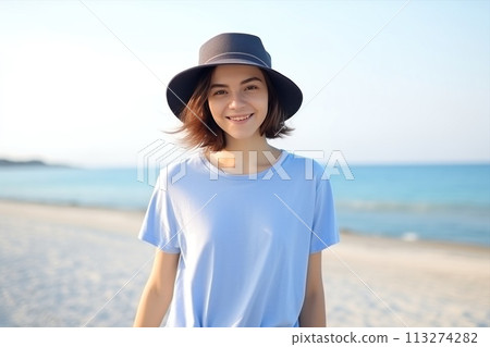 A woman in azure tshirt and jeans smiles on beach 113274282