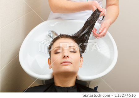 Hairdresser washing her woman customer hair Hairdresser washing her woman customer hair 113274510