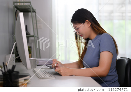 Focused young female entrepreneur checking financial data on digital tablet 113274771