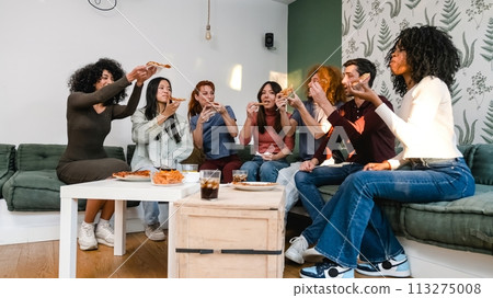 Diverse friends enjoying delicious pizza slices in living room during weekend party Diverse friends enjoying delicious pizza slices in living room during weekend party 113275008