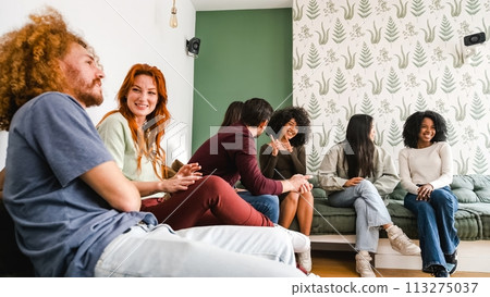 Happy diverse friends sitting on couch and talking at home 113275037