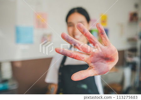 Close-up art student's hands stained after watercolor painting on canvas doing some art projects on studio workshop Close-up art student's hands stained after watercolor painting on canvas doing some art projects on studio workshop 113275683