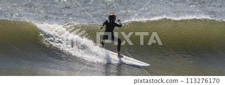 Surfer surfing on a wave at the beach 113276170