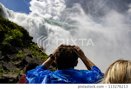 Tourists looking up at American Falls in Niagara Falls New York 113276213