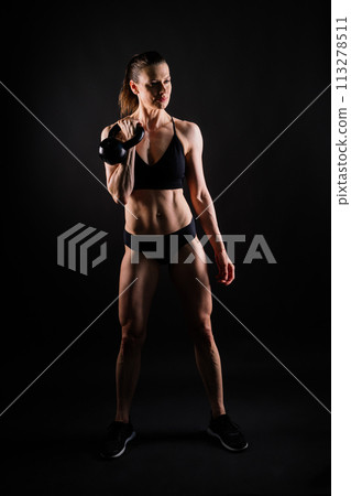 Tough fitness female model with kettle bell on grey dark yellow red background. 113278511