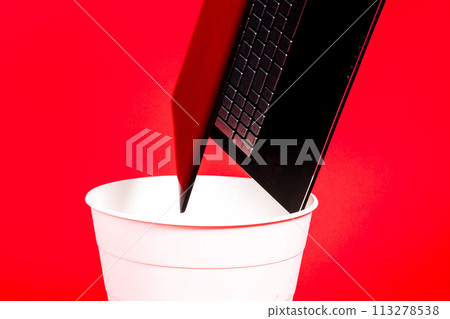 Black laptop in a trash bin on a red background isolated Black laptop in a trash bin on a red background isolated 113278538