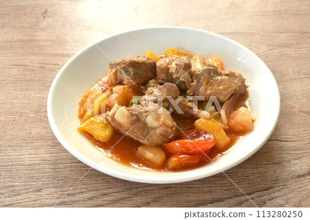 fried mixed vegetable with chop pork bone in sweet and sour gravy sauce on white plate  113280250