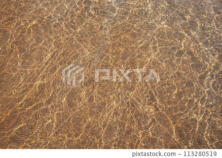 sandy beach with waves rolling in, creating a beautiful natural background. beige sand contrasts with ocean waves. concept for perfumes, smells, heat, freshness, coolness and other associations sandy beach with waves rolling in, creating a beautiful natural background. beige sand contrasts with ocean waves. concept for perfumes, smells, heat, freshness, coolness and other associations 113280519