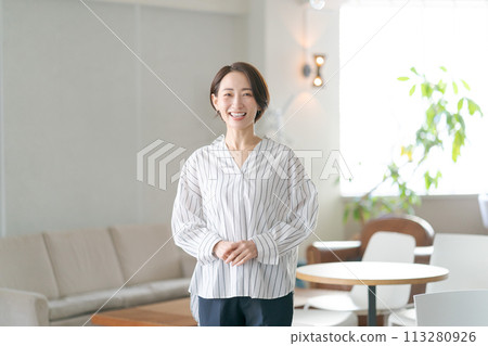 Middle-aged woman standing in the living room 113280926