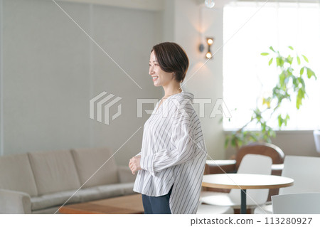 Middle-aged woman standing in the living room 113280927