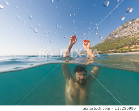 Sea summer landscape. young man sinking into the sea, under and above waterline, 113280990