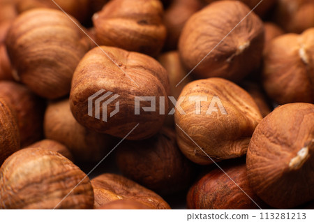 Close-up of Hulled whole cobalt or hazelnut seeds of Corylus avellana. Macro photo of food, close up from above 113281213
