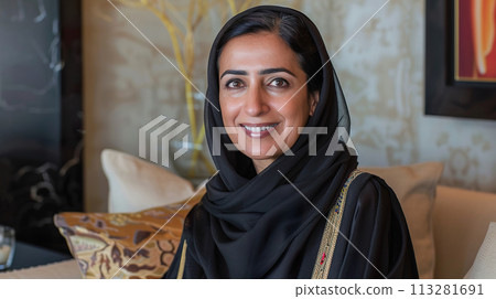 Middle aged middle Eastern woman sitting at home on couch, indoor portrait 113281691