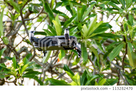 nobody, modern black drone flying in nature with 4 propellers, 4k camera photo, and video. The concept for professionals in the unmanned aircraft technology industry. Close up, crop, Blur background. nobody, modern black drone flying in nature with 4 propellers, 4k camera photo, and video. The concept for professionals in the unmanned aircraft technology industry. Close up, crop, Blur background. 113282470