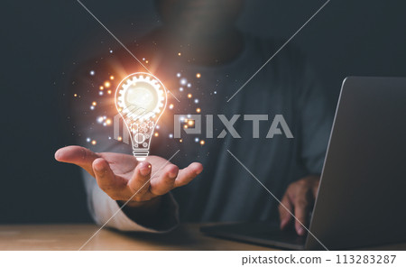 Inspiration of ideas for sustainable business development. Hand of a man holding illuminated light bulb, concept creativity with bulbs that shine glitter. an Idea of innovation and inspiration concept Inspiration of ideas for sustainable business development. Hand of a man holding illuminated light bulb, concept creativity with bulbs that shine glitter. an Idea of innovation and inspiration concept 113283287