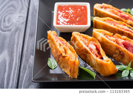 Pizza roll stromboli with cheese salami olives and tomatoes Pizza roll stromboli with cheese salami olives and tomatoes 113283365