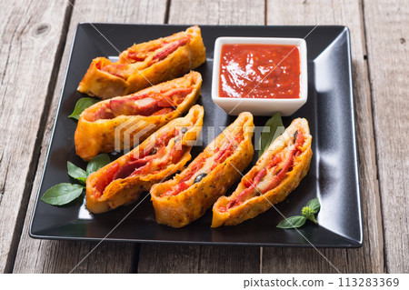 Pizza roll stromboli with cheese salami olives and tomatoes 113283369