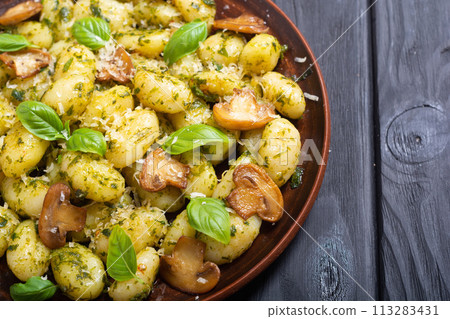 Homemade potatoes gnocchi with basil , cheese and mushrooms Homemade potatoes gnocchi with basil , cheese and mushrooms 113283431