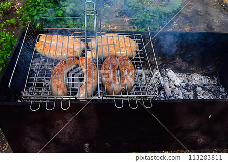 Shish kebab is fried on the grill. Food cooked on fire. Shish kebab is fried on the grill. Food cooked on fire. 113283811