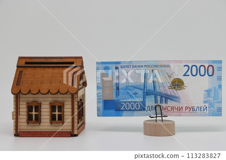The toy house stands next to the banknote on the stand. Accurate financial calculation when buying a property. 113283827