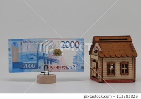 The toy house stands next to the banknote on the stand. Accurate financial calculation when buying a property. 113283829