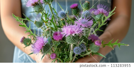 a woman holds a bouquet of thistles 113283955