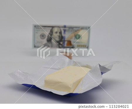 Butter in package and banknote on stand, world food crisis. Butter in package and banknote on stand, world food crisis. 113284021